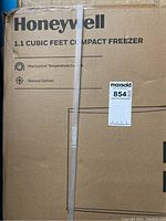 Front side of the original box showing Honeywell branding and 1.1 cubic feet compact freezer identification, features mechanical temperature control and manual defrost.