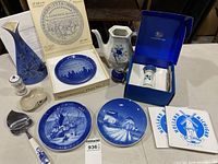Full view of blue and white porcelain collection including plates, vases, candlestick, and small figurines.