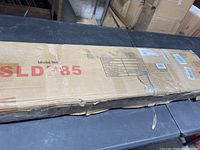 Cardboard shipping box for Serenlife dancing pole model SLDP85 with minor dents and wear, showing brand and model number on top.