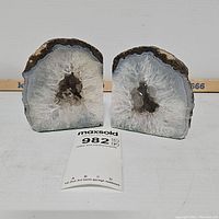 Front view of two geode bookends showing white and clear crystalline interior with natural brown edges.