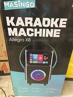 Front of box showing brand, model name, and image of the karaoke machine