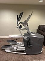 Side view of grey Octane Fitness elliptical machine showing frame, foot pedals, console support arms.