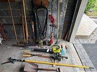 Overview of all power and hand tools against garage wall and driveway