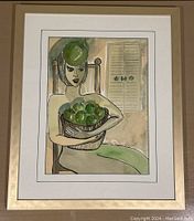 Framed abstract watercolor of a woman with a basket of green apples and a green apple hat, signed Marilyn Brooks-Coles.