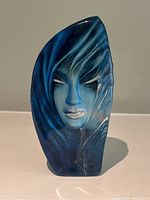 Front view showing full frontal stylized face and swirling blue patterns