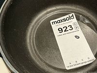 Photo of the interior of a white coated cooking pot or pan showing some wear and usage marks.
