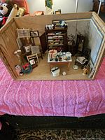Front view showing the entire miniature diorama box with furniture arrangement and items inside the wooden box