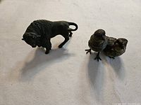 Overview of both iron figurines: bison and bird inkwell set.