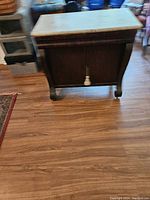 Front view of antique commode showing wood body and marble top.