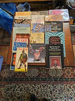 Overhead photo showing arrangement of 17 craft reference books on a textured brown carpet.