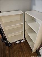 Two white IKEA Billy bookcases standing side by side showing front and side views.