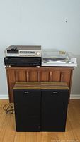 Full lot with Hitachi tuner amplifier, TEAC CD player, JVC turntable on top of wood cabinet, Sony SS-915 speakers in front.