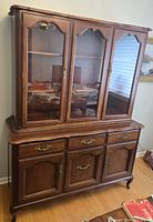 Full front view of two-piece hutch showing glass display top and buffet base