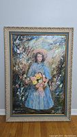 Full view of framed painting showing girl in blue dress holding basket of flowers, impressionistic style.