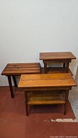 Three vintage small wooden tables grouped together, showing overall condition and size differences.