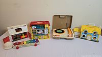 Full lot overview showing the record player, several Fisher Price playsets, and xylophone toy.