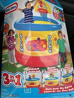 Boxed Little Tikes 3-in-1 Slam Dunk Big Ball Pit showing children playing with the inflatable basketball hoop, ball pit, and bounce trampoline.