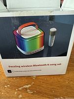 Box showing product image and product name 'Dazzling wireless Bluetooth K-song set' with a rainbow color speaker and microphone