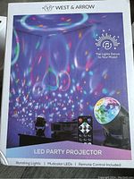 Front packaging showing LED party projector with multicolor rotating lights and remote control, highlighting lights dancing to music.