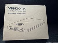 Original cardboard box of Veejtomx 10000mAh power bank showing product illustration and branding.