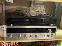 Full view of Toshiba CD player on top of Pioneer stereo receiver with cables and connectors on top, showing lot contents.