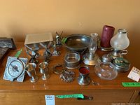 Full view of the pewter collection with clock, windmills, goblets, bowl, lamps and other items on table
