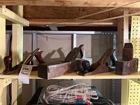 Four woodworking planes arranged on a shelf. Various sizes and wear visible. Front wooden knobs and handles visible.