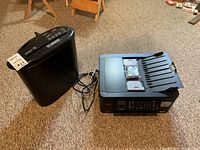 Photo showing Brother MFC-J491DW multifunction printer next to ID Armor paper shredder on carpeted floor