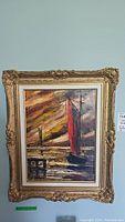 Frontal image of the framed nautical oil painting showing the boat with red and green sails and dock under a dramatic sky.