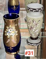 Photo showing both Bohemian glass vases side by side on glass shelf