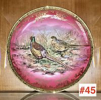 Front view of the decorative plate showing pheasant pair paintwork over pink background and gold floral border