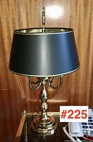 Full view of brass table lamp with black shade showing overall condition and style.
