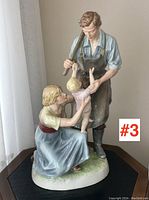 View of porcelain figurine showing man, woman and child in family scene with natural daylight from window.