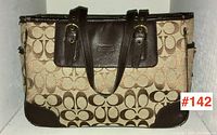 Front view of vintage COACH handbag showing signature canvas pattern, leather handles and leather panel with logo.