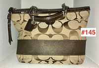 Front view of vintage Coach handbag showing signature 'C' canvas pattern with dark brown satin stripe and leather handles.