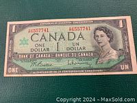 Front side of the 1967 Canadian Centennial one dollar bill showing Queen Elizabeth II and serial numbers.