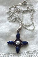 Front view of the pendant with pearl center and four blue lapis marquise cabochons, attached to the silver chain.