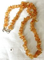 Full length view of the citrine chip necklace showing the silver tone lobster clasp and the warm amber chips.