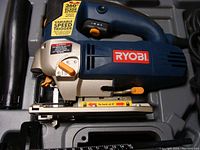 Ryobi JS550L jig saw inside case, showing blue body, orange/yellow controls, and handle.