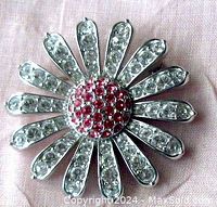 Front close-up showing floral daisy design with pink center crystals and clear petals, all pavé set in rhodium plated metal.