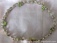 Full view of the two-tone link bracelet laid flat on fabric