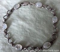 Full view of the bracelet laid flat showing oval moonstones and silver links.