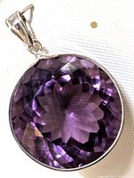 Front view of round faceted purple amethyst in 14K gold bezel and bail