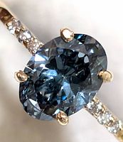 Close-up top view of oval blue lab-grown diamond and pavé band