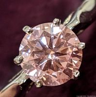 Close-up of round brilliant-cut pink moissanite in six-prong setting