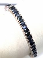 Angled close-up of row of oval-cut sapphires in prong settings