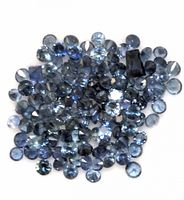 Close-up image showing multiple loose round and one rectangular cut blue sapphires on a white background.