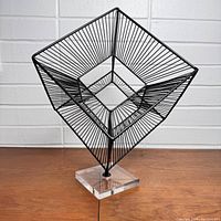 Front angled view of black wire cubist cube sculpture on acrylic base showing intricate wireframe structure.