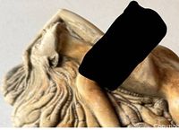 Close-up image showing detailed carving of the reclining nude female figure integrated with fossil-inspired elements.