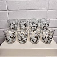 Front view of six vintage low ball glasses decorated with dogwood branches and white blossoms.